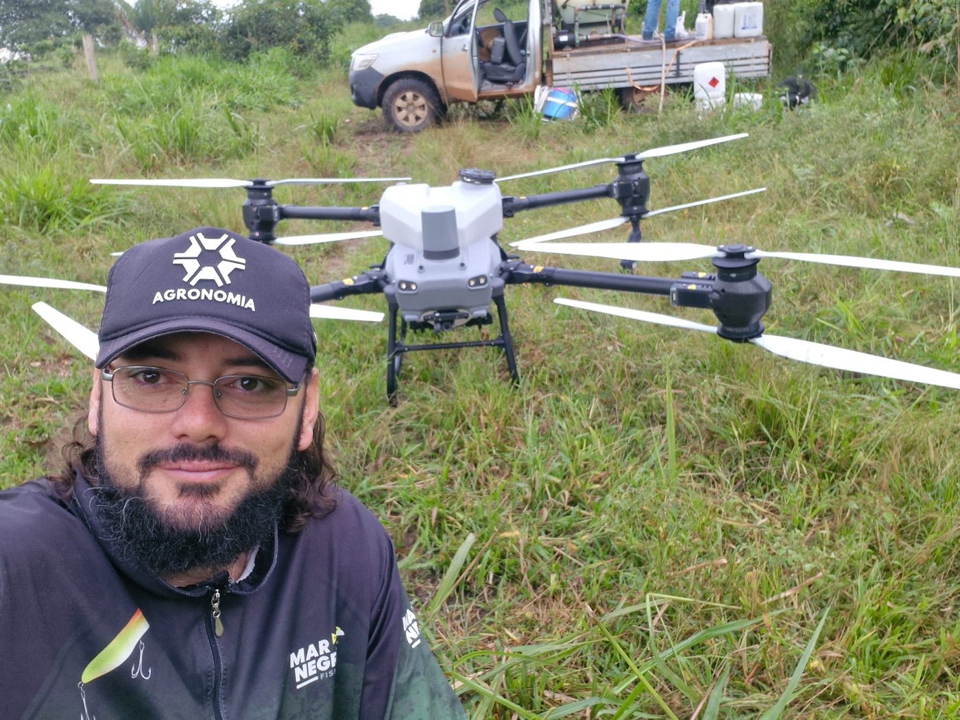 Engenheiro agrônomo da Paradigma Drones ao lado de drone agrícola de pulverização em lavoura de Aripuanã - MT